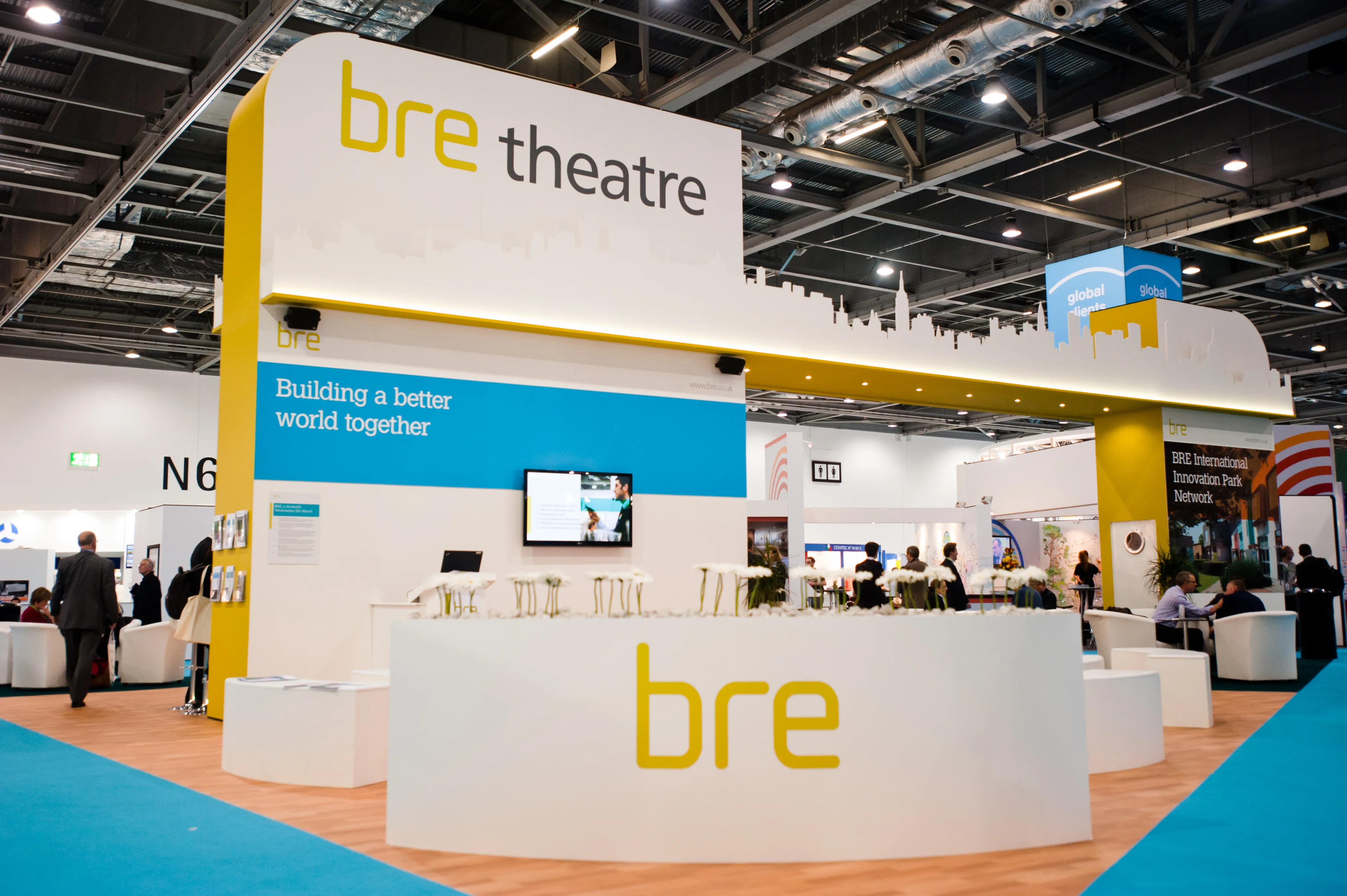 Lounge-style exhibition stand with branded furniture and plants