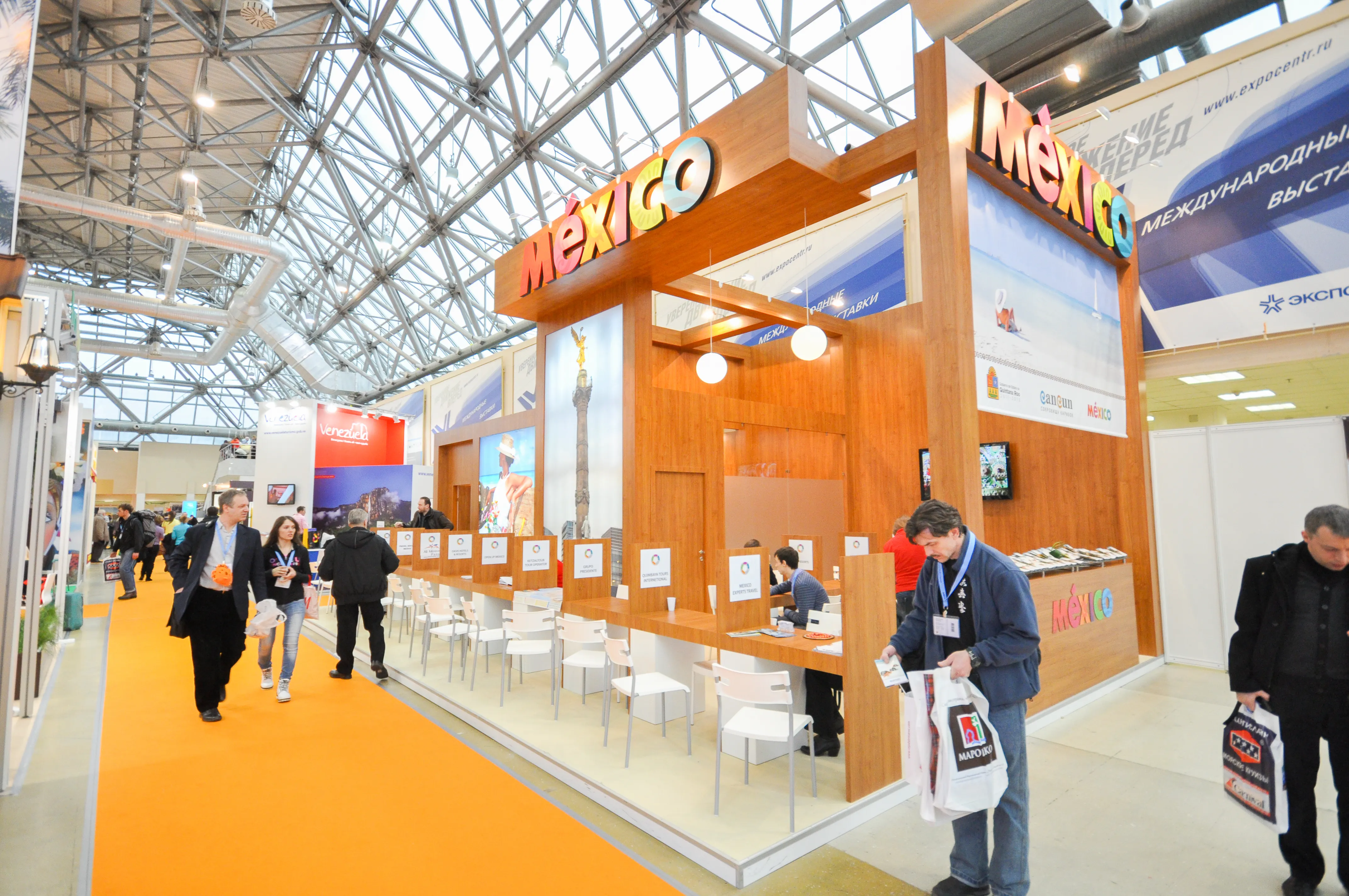 Lounge-style exhibition stand with branded furniture and plants